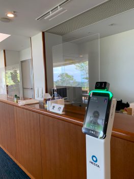 アクリル板とカメラ測定による体温計を設置した受付